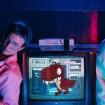 deux teenagers à côté d'une télé avec le Raptor