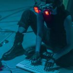 pollution numérique : une femme assise avec un casque VR et entourée de cables