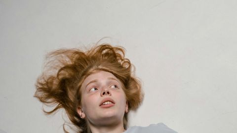 Un jeune femme rousse effrayée par un cafard qui se dirige vers elle