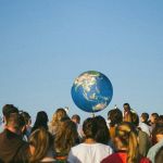 une foule de dos et une planète au fond