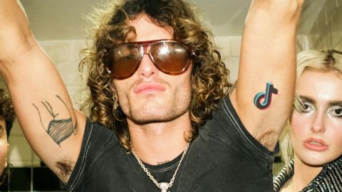 Comment TikTok entretien la panique des tiktokeurs pour défendre sa position aux USA Deux jeunes hommes et une femme blondeambiance rock avec tatouage TikTok