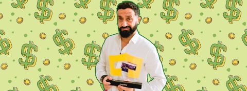 Hanouna rejoint Royaltiz : voulez-vous miser sur la carrière de Cyril H. ? Hanouna souriant, portant un trophée Royaltiz sur fond de dollars