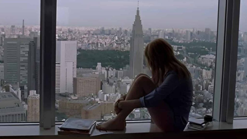 Solitude, grandes villes et Stanley Cups Une silhouette de femme qui regarde la ville d'une fenêtre