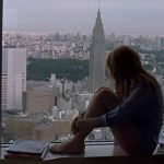 Une silhouette de femme qui regarde la ville d'une fenêtre