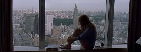 Solitude, grandes villes et Stanley Cups Une silhouette de femme qui regarde la ville d'une fenêtre