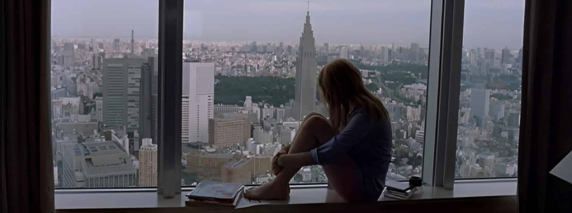 Solitude, grandes villes et Stanley Cups - L'ADN Une silhouette de femme qui regarde la ville d'une fenêtre