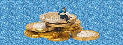 L'IA, combien ça coûte et est-ce que cela vaut le coût ? Un petit personnage miniature en plastique assis sur des pièces