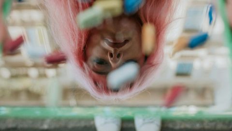 Une jeune fill tient un miroir recouvert de pilules