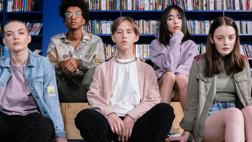 Cinq jeunes ados, filles et garçons, dans une bibliothèque