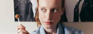 Une jeune femme rousse, regard au ciel avec une sucette