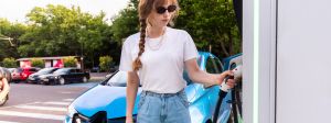 Une juene femme recharge sa voiture électrique
