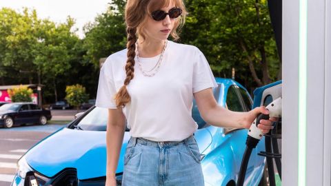 Une juene femme recharge sa voiture électrique