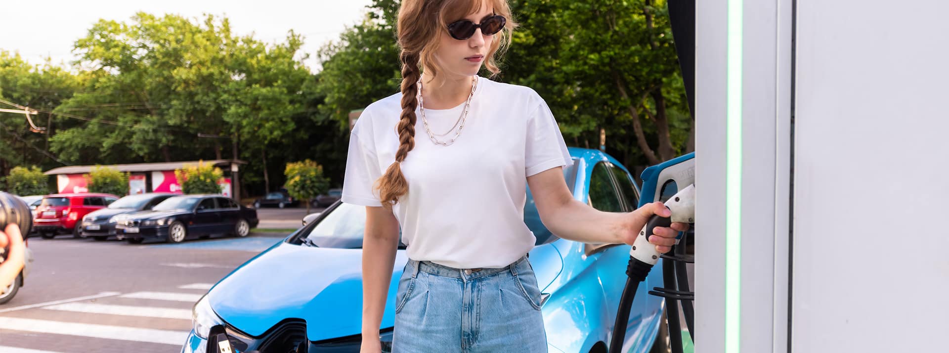 « Tout le monde devrait vouloir bosser. dans les transports !» - L'ADN Une juene femme recharge sa voiture électrique