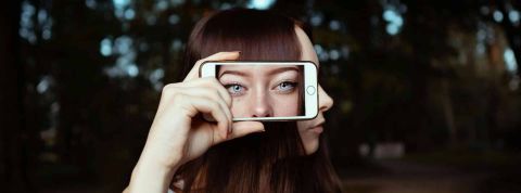 troll une fille qui pose avec un smartphone sur le côté de sa tête