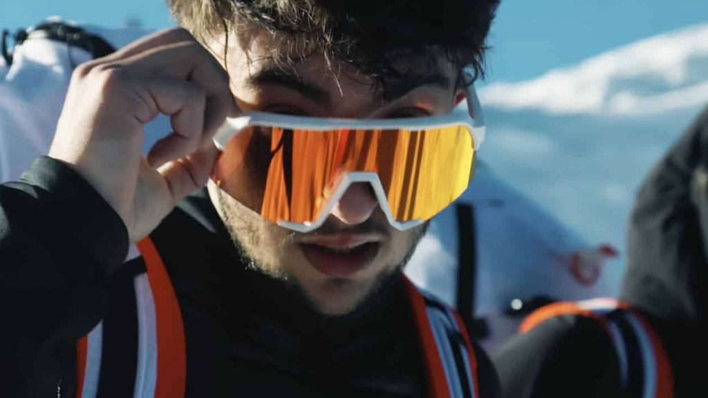 un homme en tenue d'alpiniste regarde la caméra