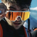 un homme en tenue d'alpiniste regarde la caméra