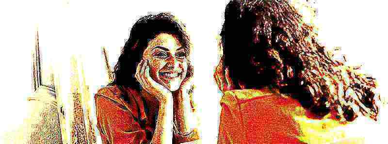 Une femme qui se regarde dans un miroir en souriant