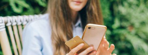 « Le citoyen possède un contre-pouvoir, celui de sa carte bancaire » Les mains d'une jeune femme, tenant sa CB et son portable