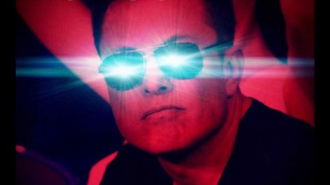 elon muske en filtre rouge avec les yeux bleu qui brillent.