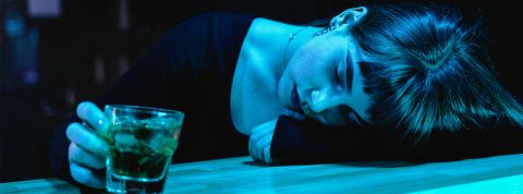 Violences sexuelles à l’université : quand l’alcool gâche la fête Une jeune femme avec un verra à la main effondrée sur un bar