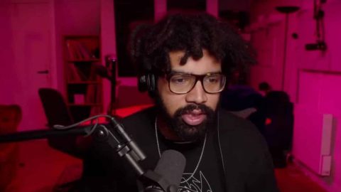 un homme noir avec des dreads devant un micro