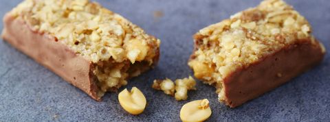 Plus de muscles et une santé améliorée : les barres protéinées sur-promettent sans complexe Still life d'une barre protéinée aux cacahuètes