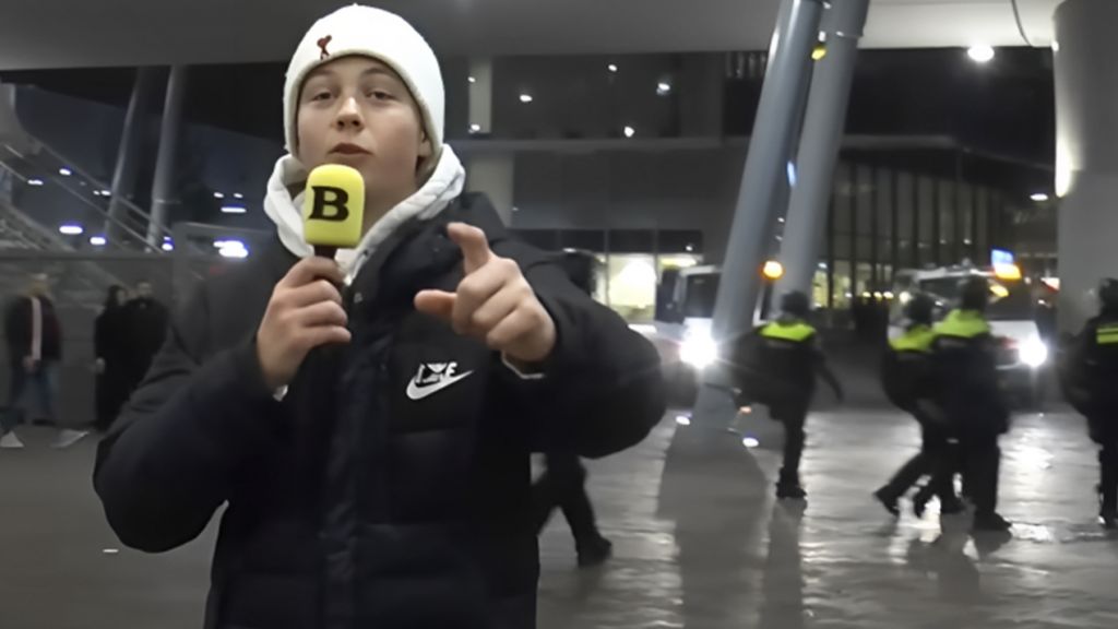 une jeune garçon au bonnet blanc devant un stade