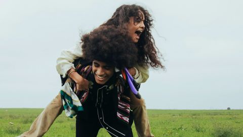 Un jeune couple s'amuse dans un champ