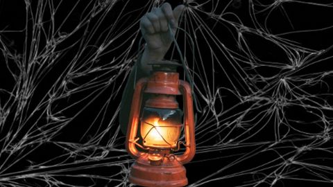 Une main qui sort du noir avec une lanterne