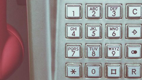 Un vieux clavier de cabine téléphonique avec un combiné rose