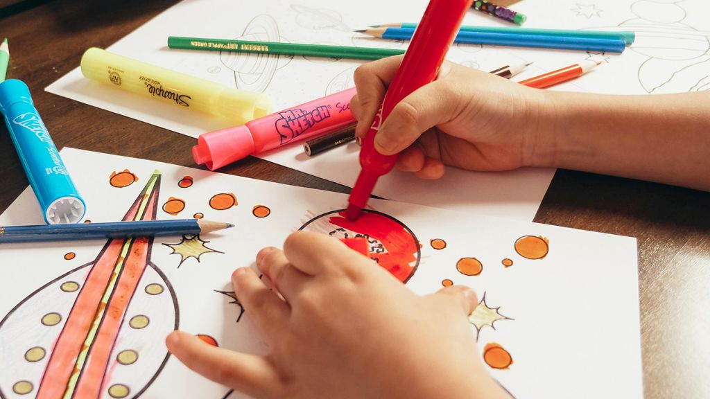 Gros plan sur les mains d'un enfant qui dessine