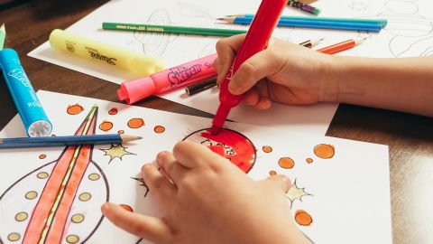 Gros plan sur les mains d'un enfant qui dessine