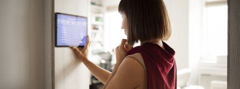 Home-heat femme régulant la température de son appartement avec un appareil connecté