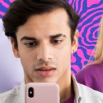 De jeunes ados avec le garçon au centre sur son smartphone, les autres les yeux dans le vague