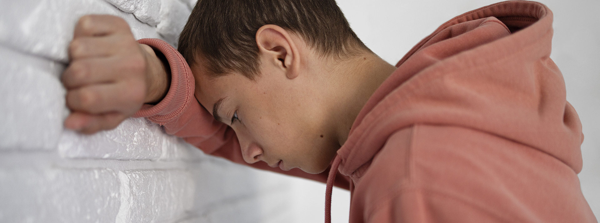 Converser avec des IA est-il dangereux ? - L'ADN Un jeune garçon tête contre le mur, super déprimé