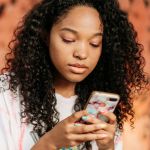 Une jeune metisse sur son smartphone