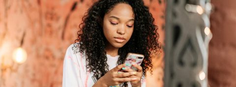 Les psys sur les réseaux : Des influenceurs qui vous veulent du bien ? Une jeune metisse sur son smartphone