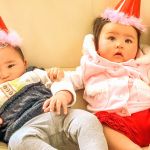 Quatre bébés asiatiques avec des chapeaux de fête en carton