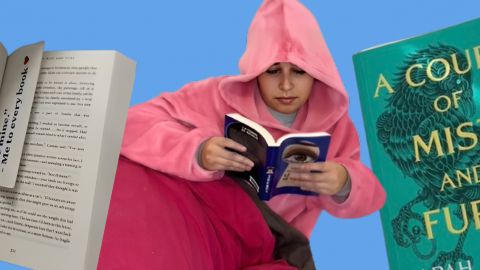 Une jeune fille lovée dans un sweat à capuche lit un livre