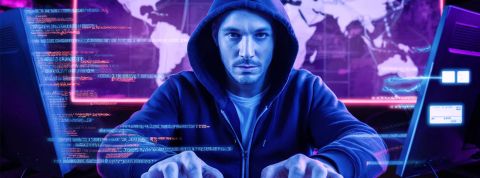 343 milliards d’euros d’ici 2027 : les fraudes e-commerce explosent Un hacker devant son écran avec une carte du monde derrière lui