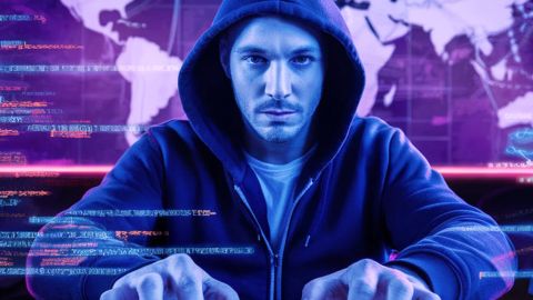 Un hacker devant son écran avec une carte du monde derrière lui