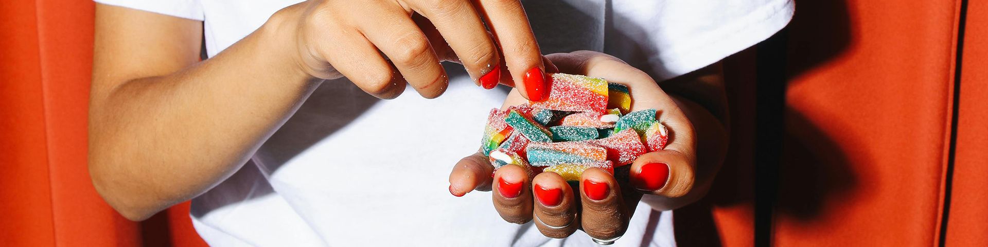 Dis-moi comment tu manges Les mains manucurés d'une femme sans lesquels se trouvent des bonbons