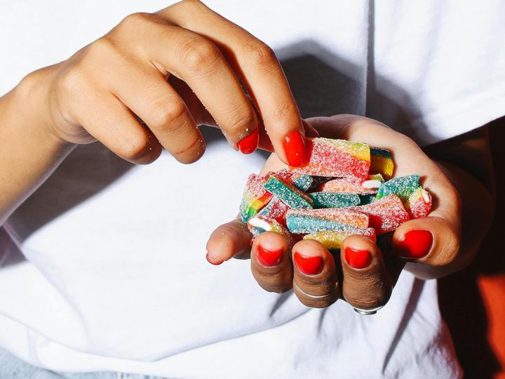 Les mains manucurés d'une femme sans lesquels se trouvent des bonbons