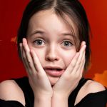 Une petite fille inquiète sur un fond de ciel rouge