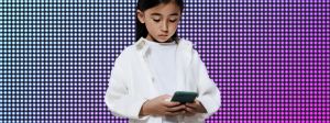 une petite fille regarde son portable