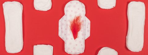 Données intimes et promesses trompeuses : la face cachée des applis de cycle Des serviettes hyginéiques blanches et la centrale avec une plume rouge