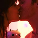 Un couple s'embrasse tandis qu'un petit robot les regarde