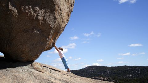 Un garçon tente d'arrêter un immense rocher qui roule
