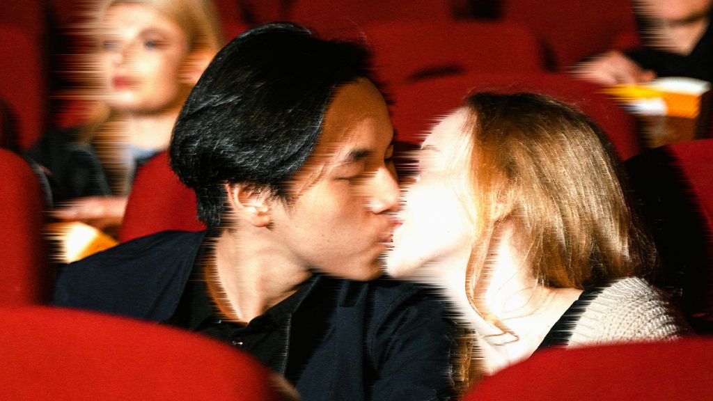 Un jeune couple s'embrasse dans un cinéma