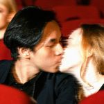 Un jeune couple s'embrasse dans un cinéma